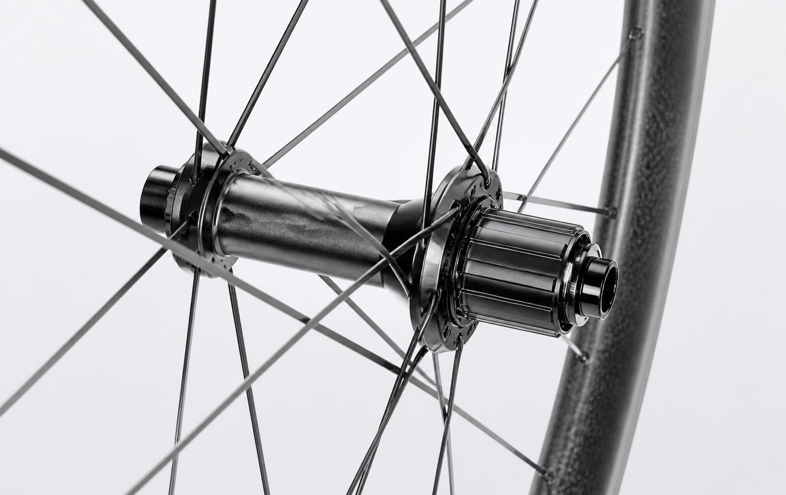 Bright macro detail of a carbon bicycle hub shell and spokes