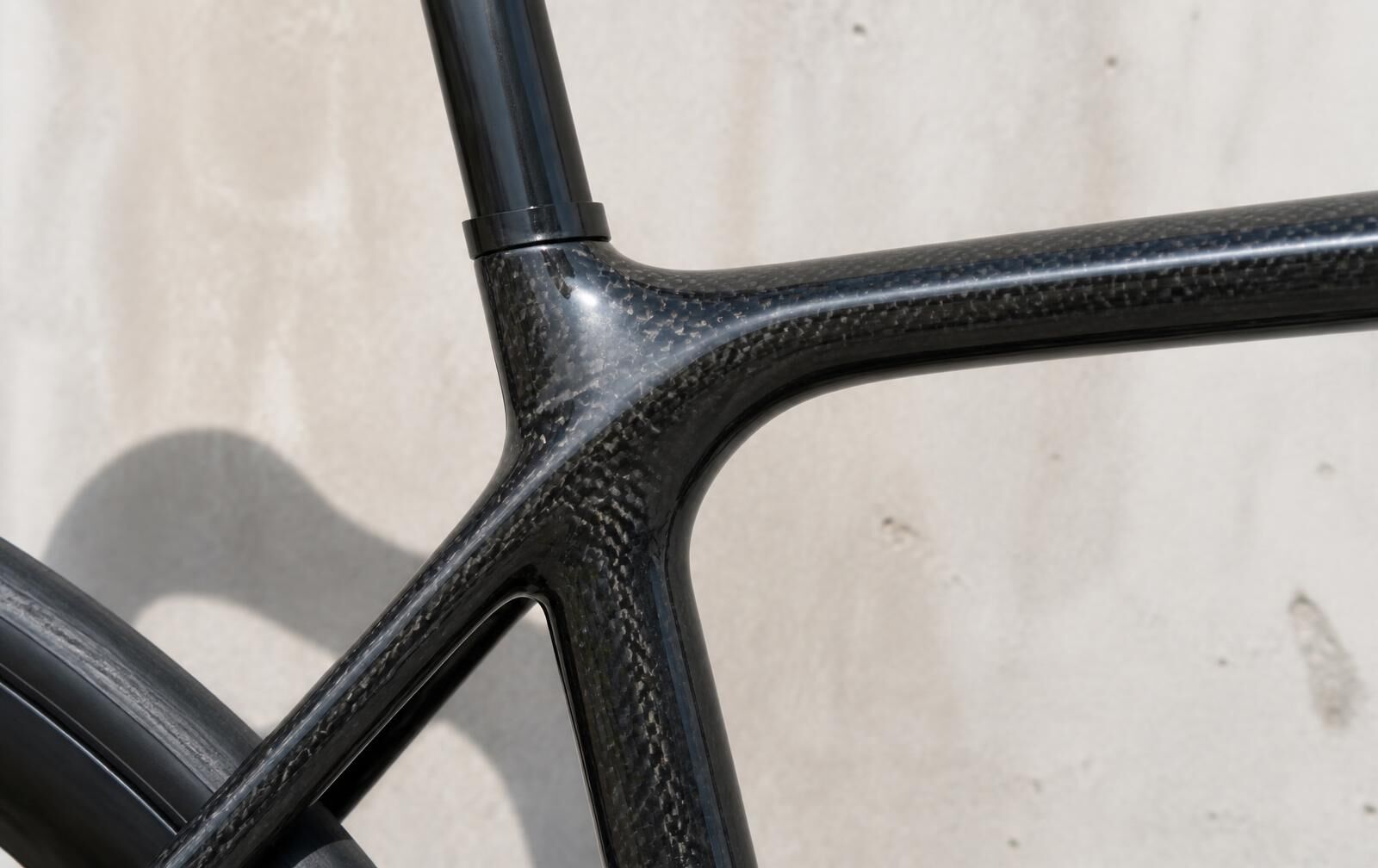 Close-up of a carbon bicycle frame junction in bright daylight